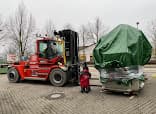 Gabelstapler transportiert eine abgedeckte Maschine